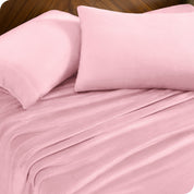 Two pillows with pillowcases on them set on a bed with matching sheets