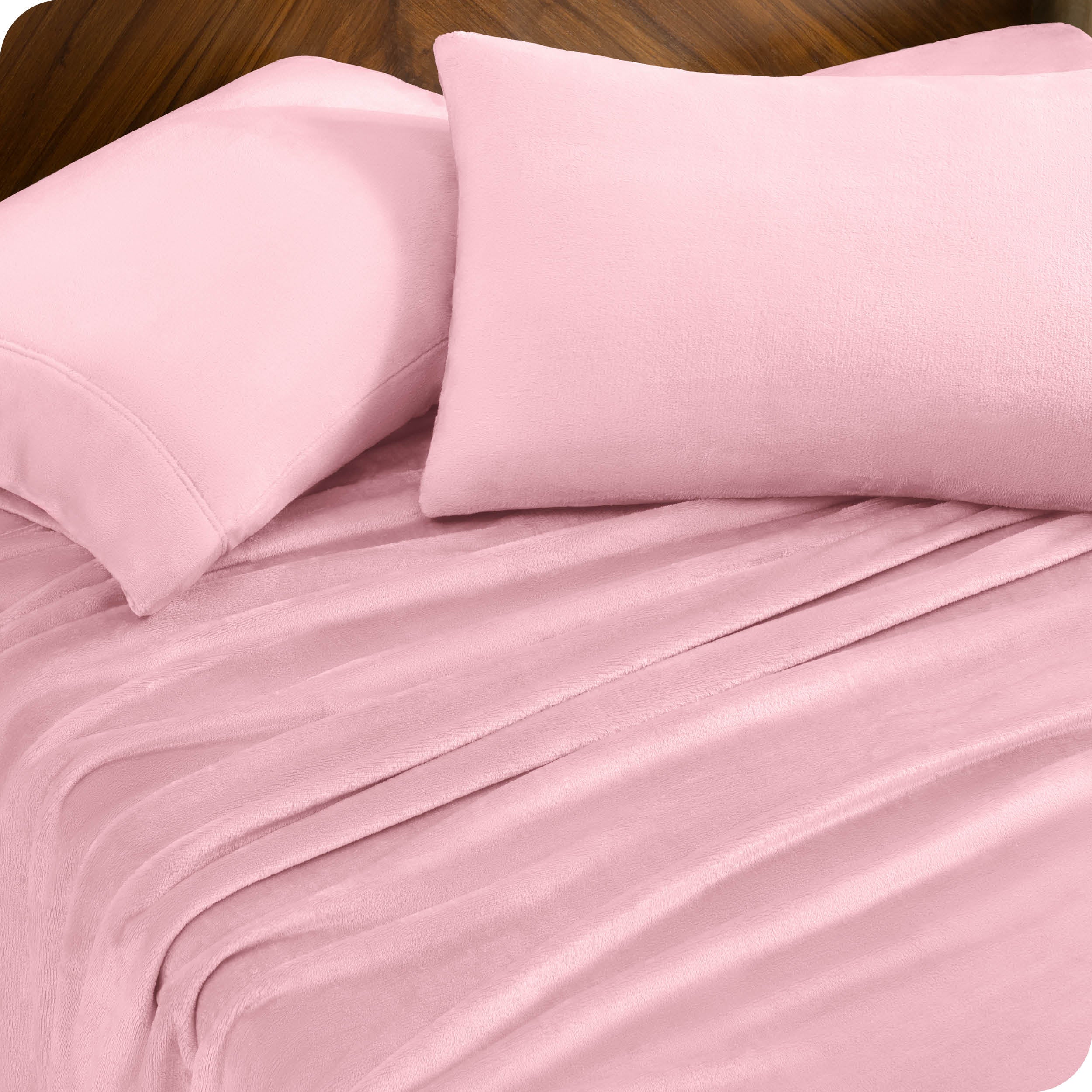 Two pillows with pillowcases on them set on a bed with matching sheets