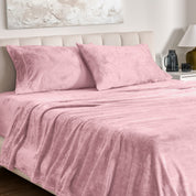 Microplush bed sheets and pillowcases on a bed with a neutral headboard and decor.
