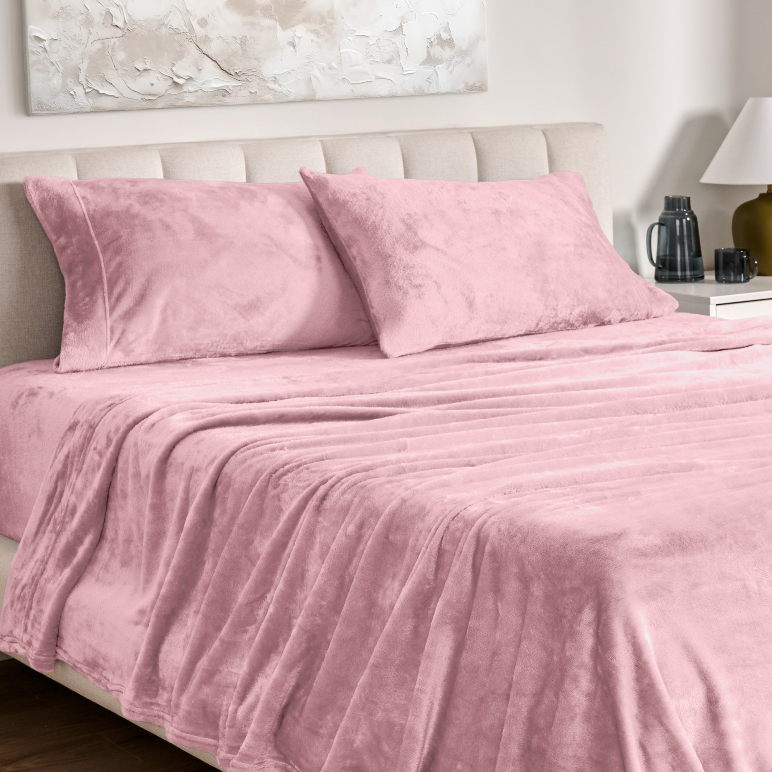 Microplush bed sheets and pillowcases on a bed with a neutral headboard and decor.