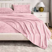 Microplush sheets on a bed in a bedroom setting with a nightstand and lamp.