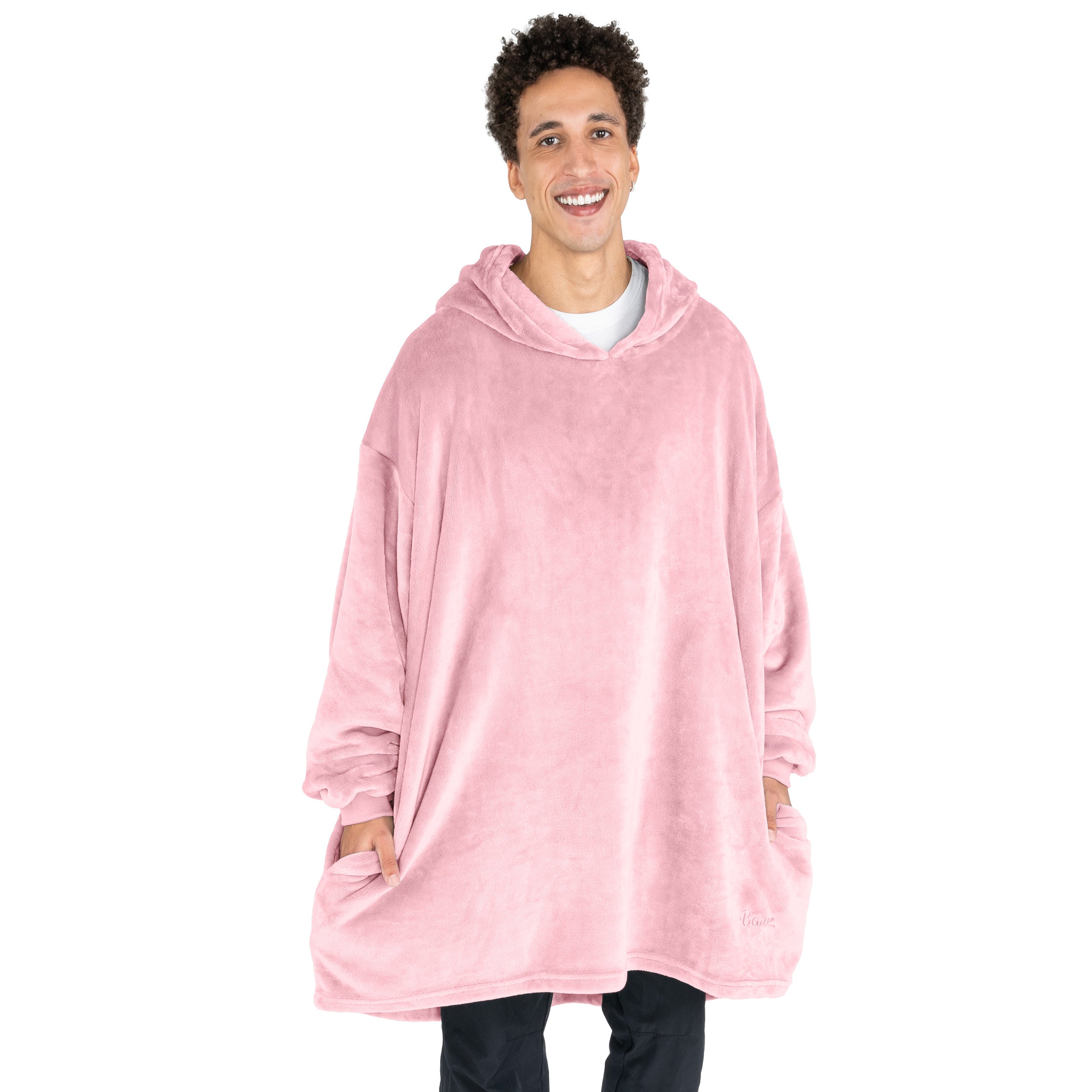 A man has a microplush wearable blanket on and his hands are in the side pockets