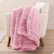 A shaggy faux fur blanket draped over the arm of a chair