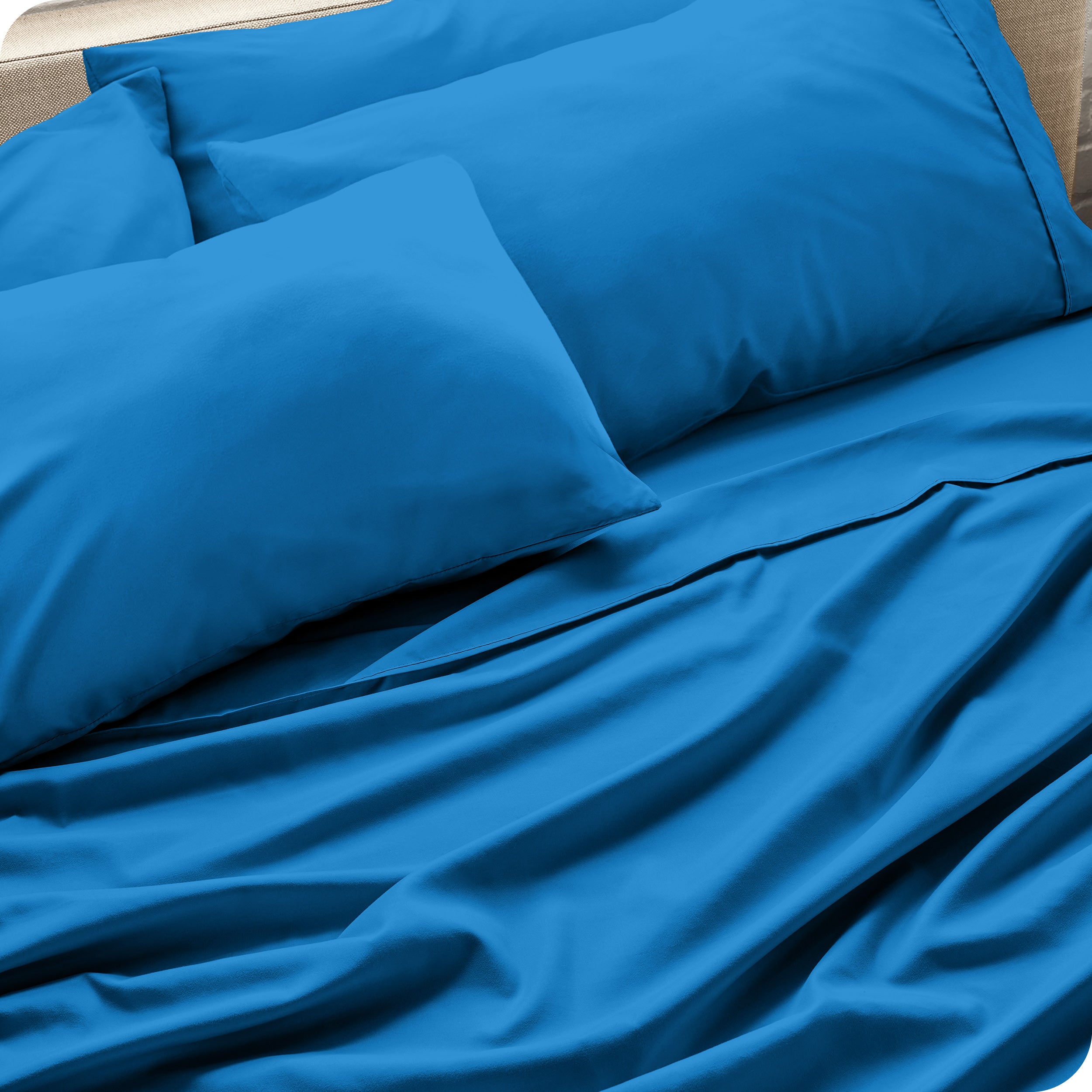 Close up of the microfiber bed sheets on a bed with four pillows.