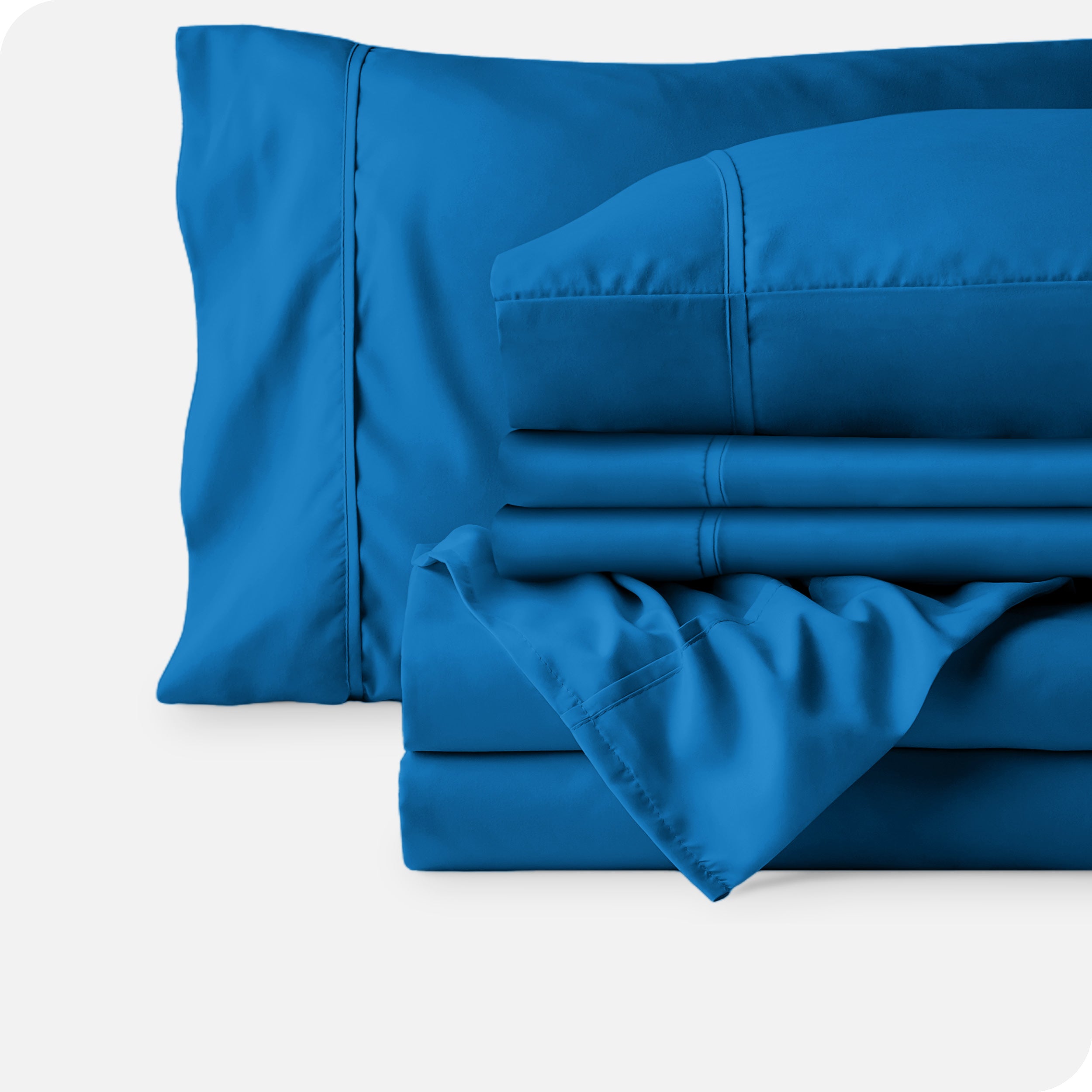 Microfiber sheets neatly folded with corner draped over, two folded pillowcases and two display pillows.