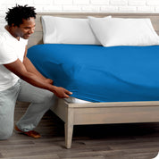 A man putting the microfiber fitted sheet on a mattress. 