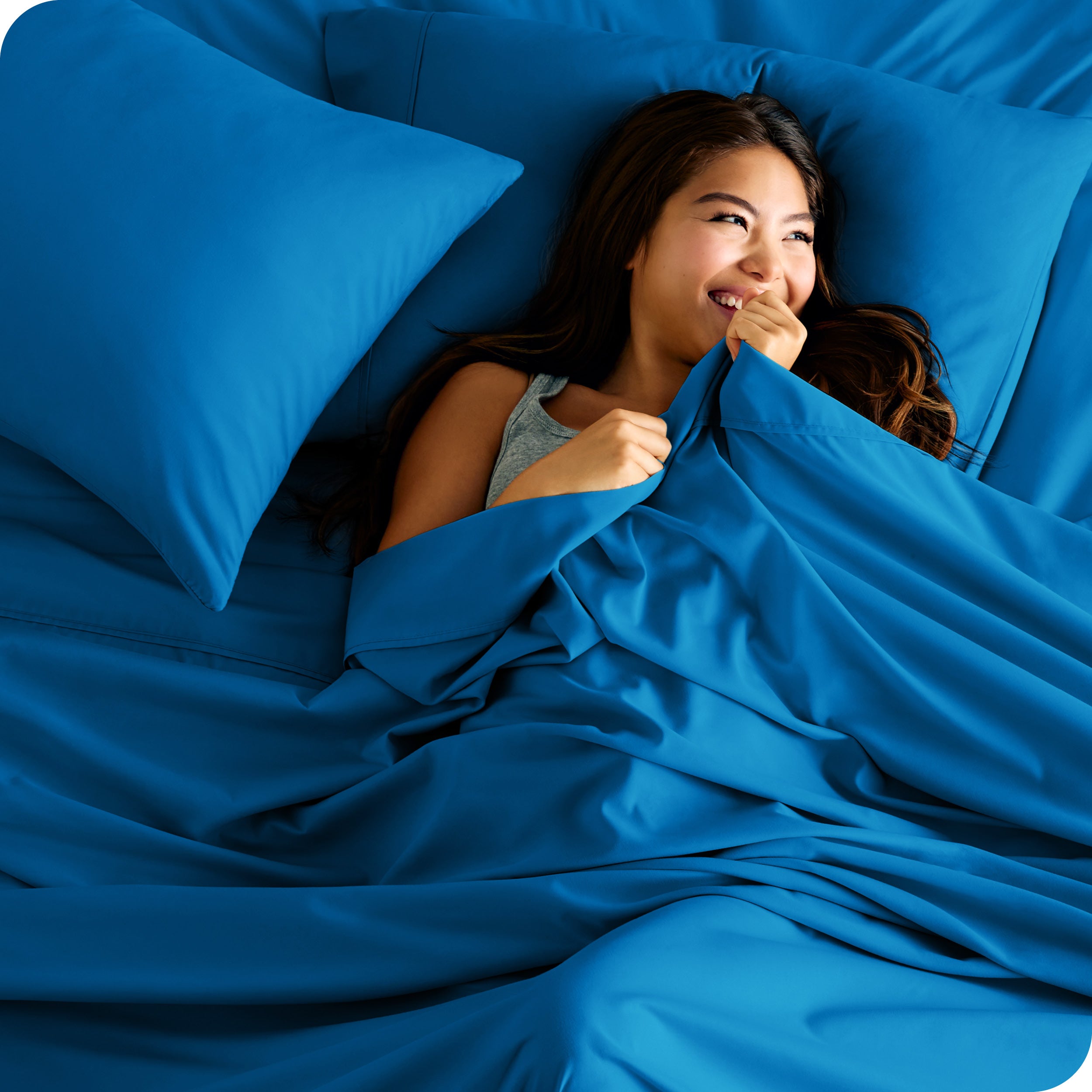 A woman in bed wrapped in microfiber sheet sets
