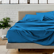 Microfiber sheets on a bed with a brick wall behind it