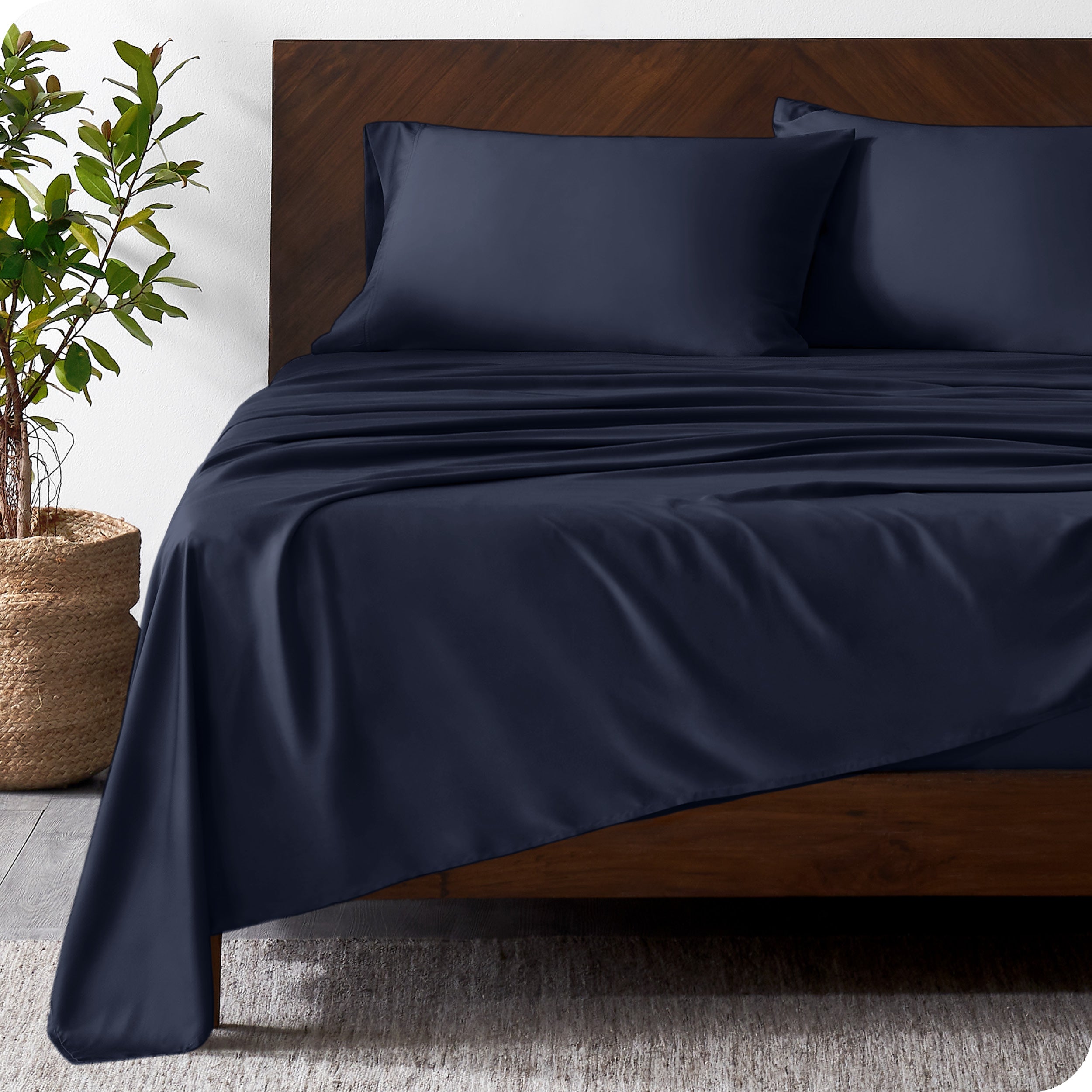 Wooden bed frame with bamboo sheets on the bed