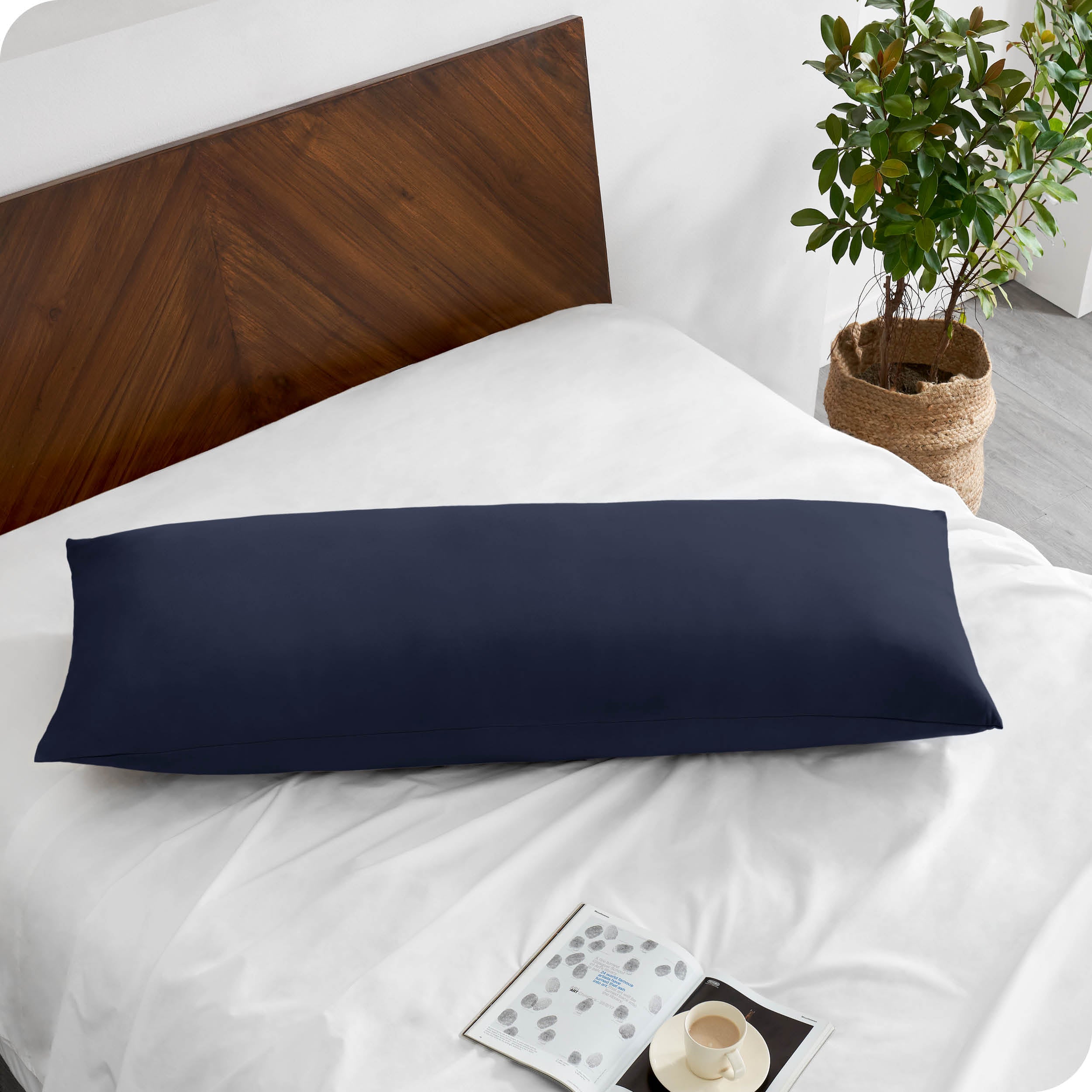 A body pillowcase on a pillow on a bed with all white bedding