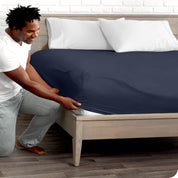 A man putting the microfiber fitted sheet on a mattress. 