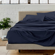 Microfiber sheets on a bed with a brick wall behind it
