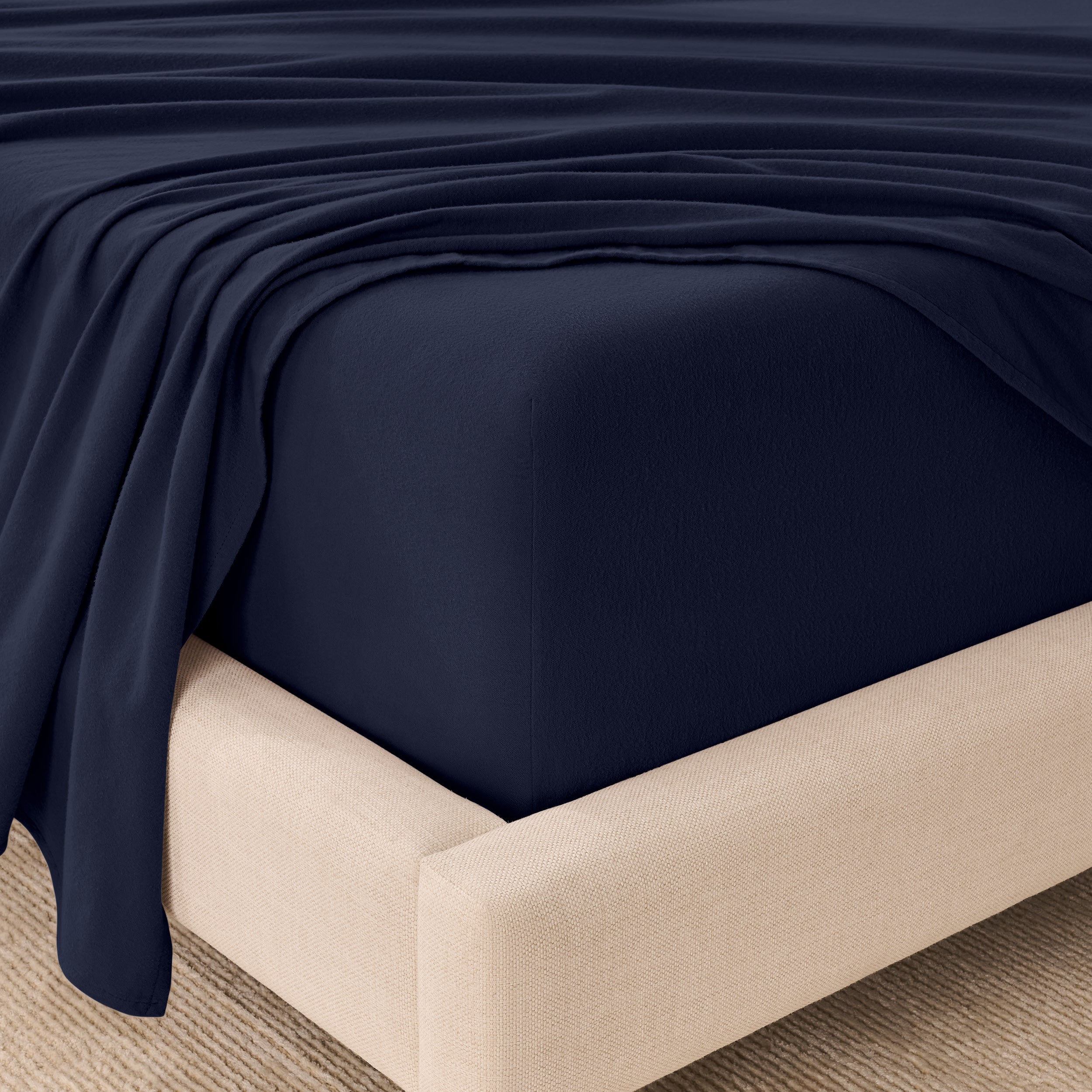 Organic flannel sheets on a beige bed frame