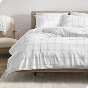 A comforter set on a bed with a dark wooden headboard