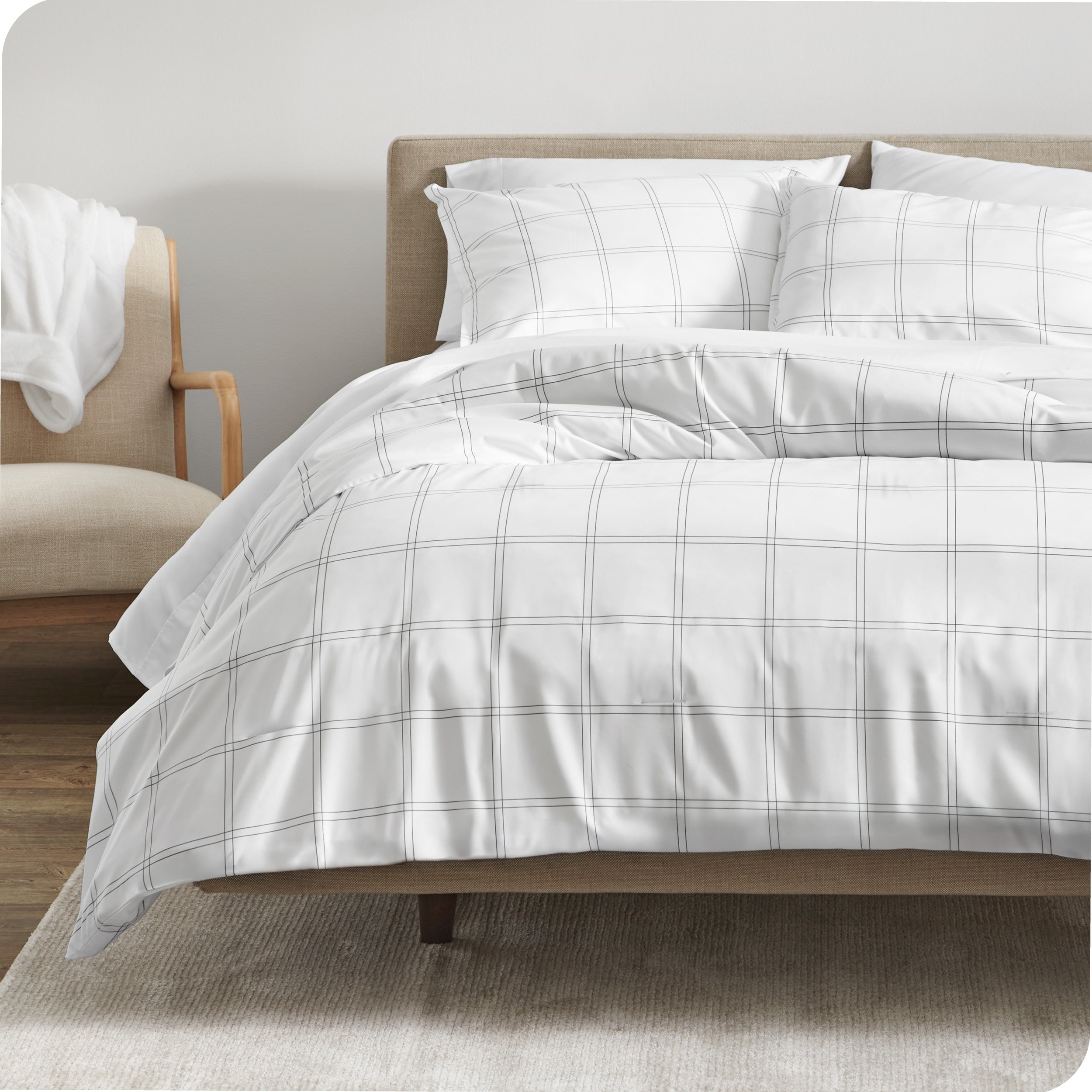 A comforter set on a bed with a dark wooden headboard