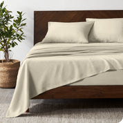 Luxury Linen Sheet Set is on a bed in a warm modern room.