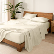 Wooden bed frame with  linen sheets on the mattress