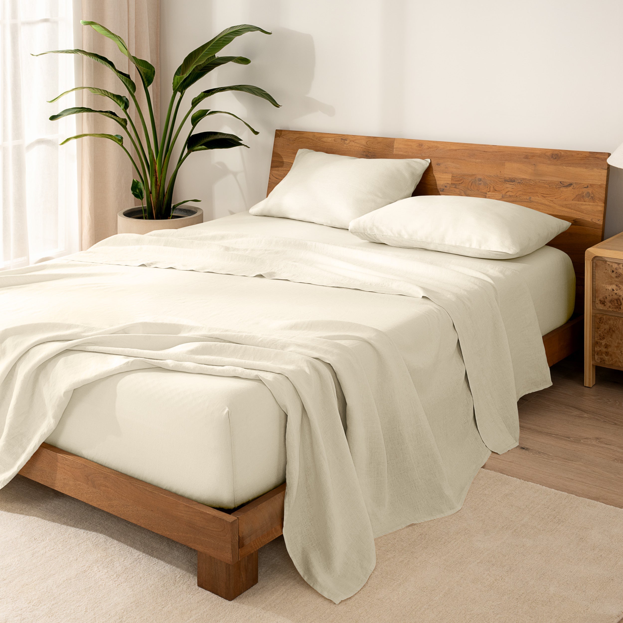 Wooden bed frame with  linen sheets on the mattress