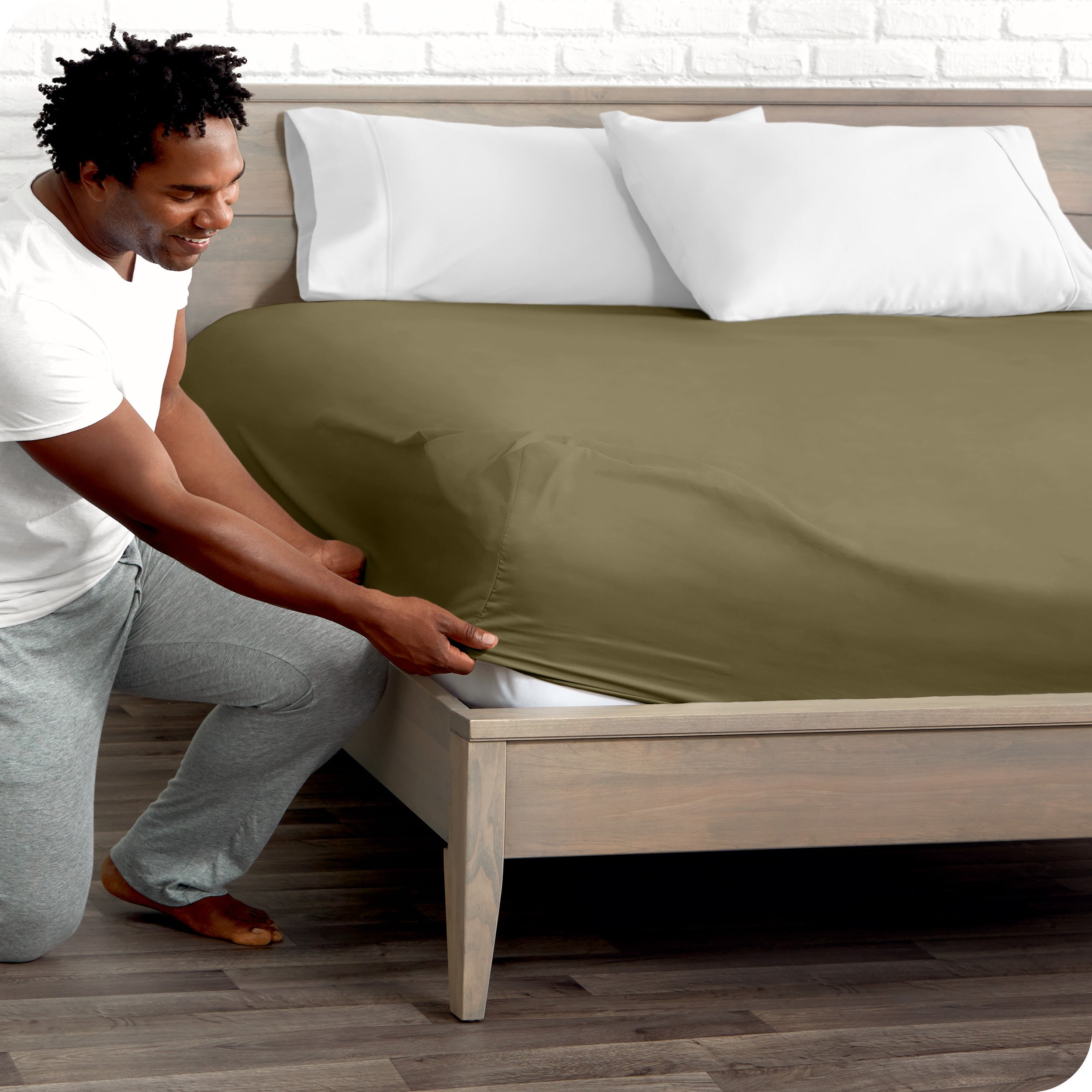 A man putting the microfiber fitted sheet on a mattress. 