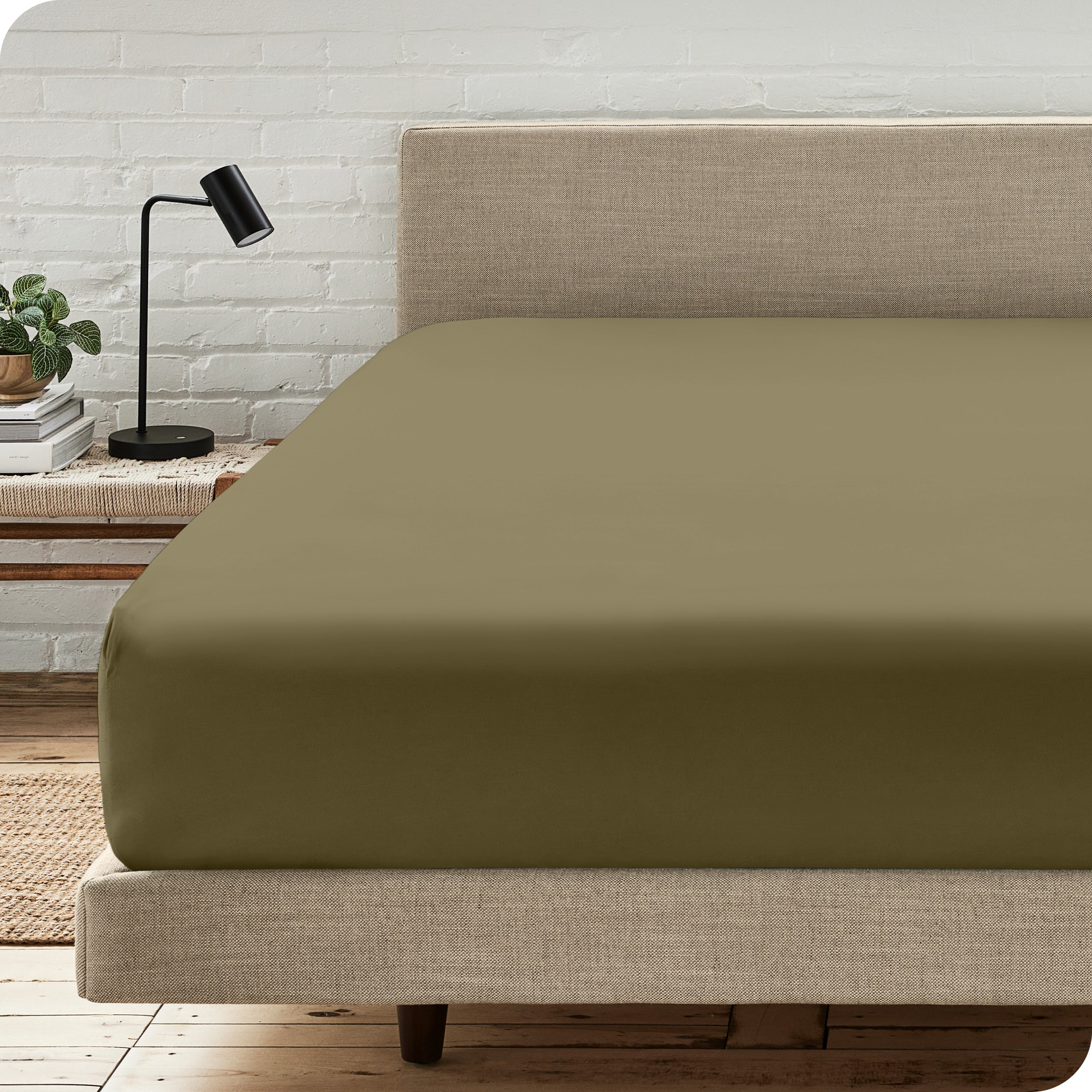 A bed with a microfiber fitted sheet on the mattress. 