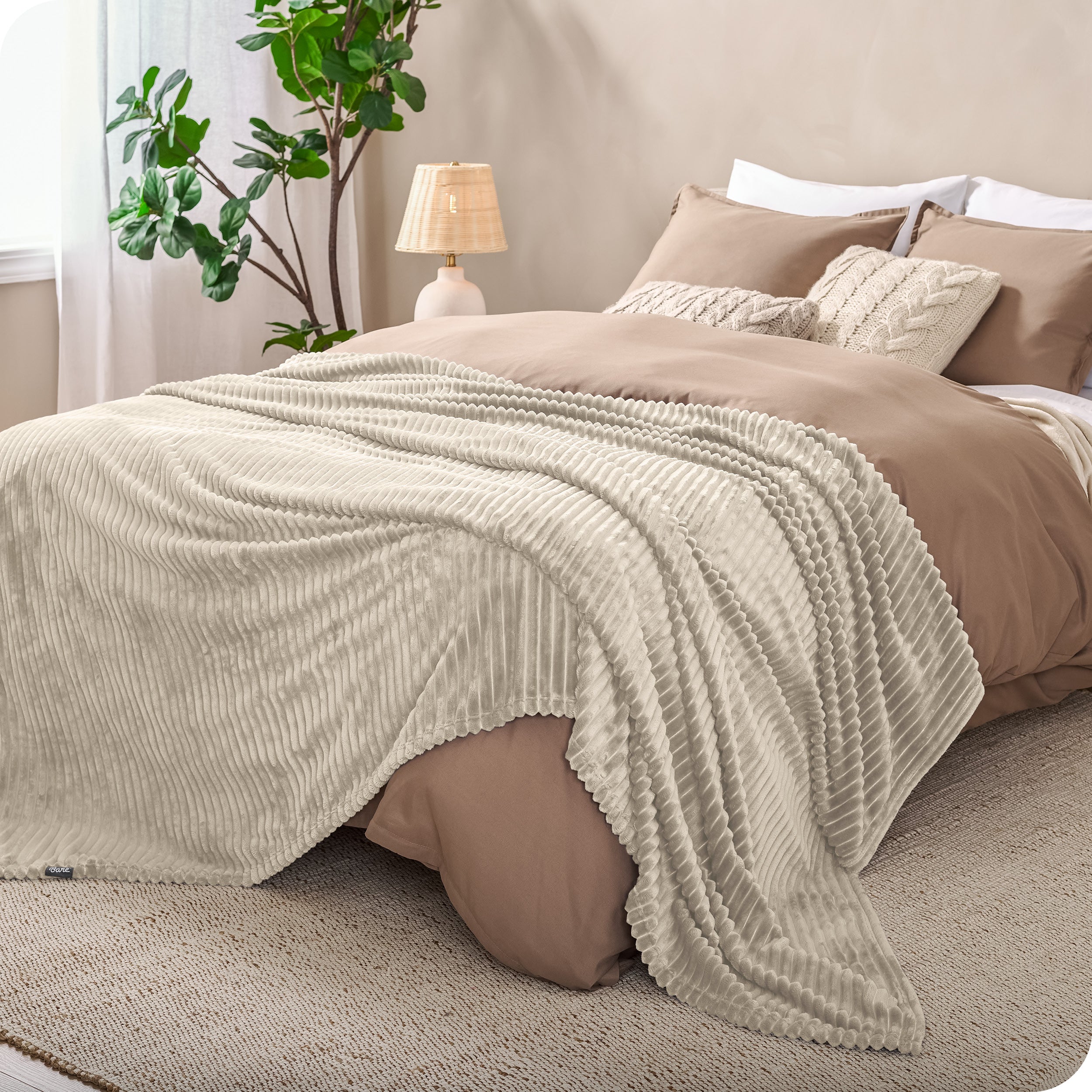 A microplush blanket spread out over the end of a bed
