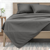 View from the end of a modern bed made with a microfiber sheet set with a modern print. 