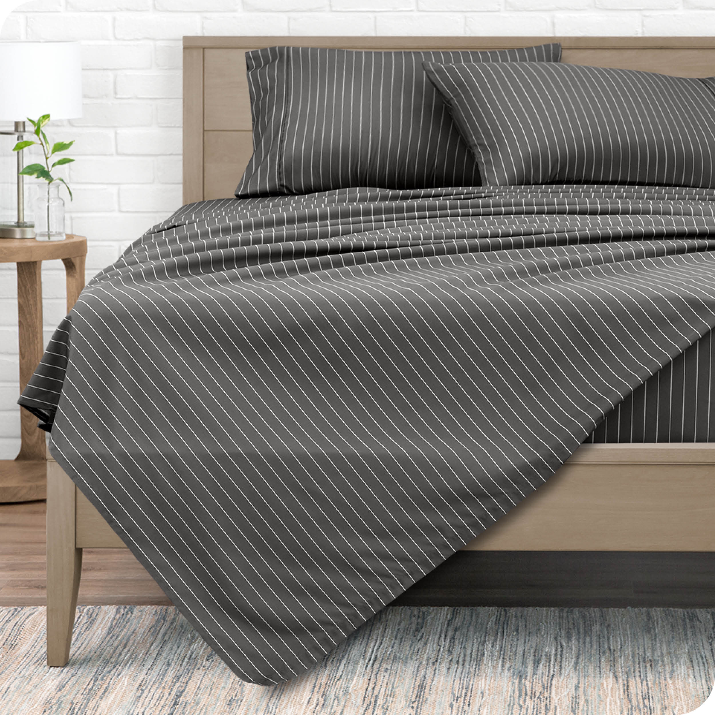 View from the end of a modern bed made with a microfiber sheet set with a modern print. 