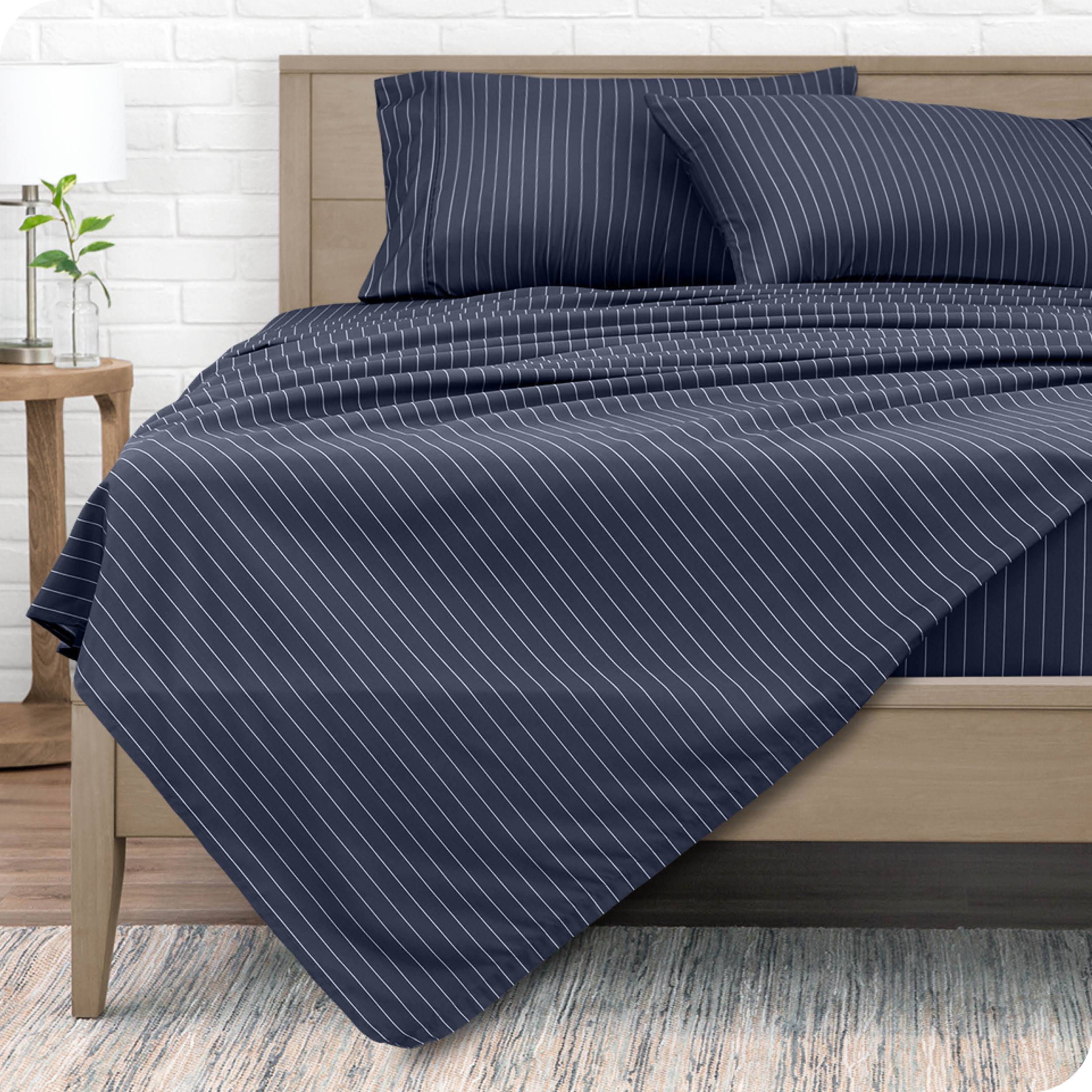 View from the end of a modern bed made with a microfiber sheet set with a modern print. 