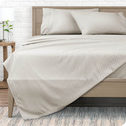 View from the end of a modern bed made with a microfiber sheet set with a modern print. 