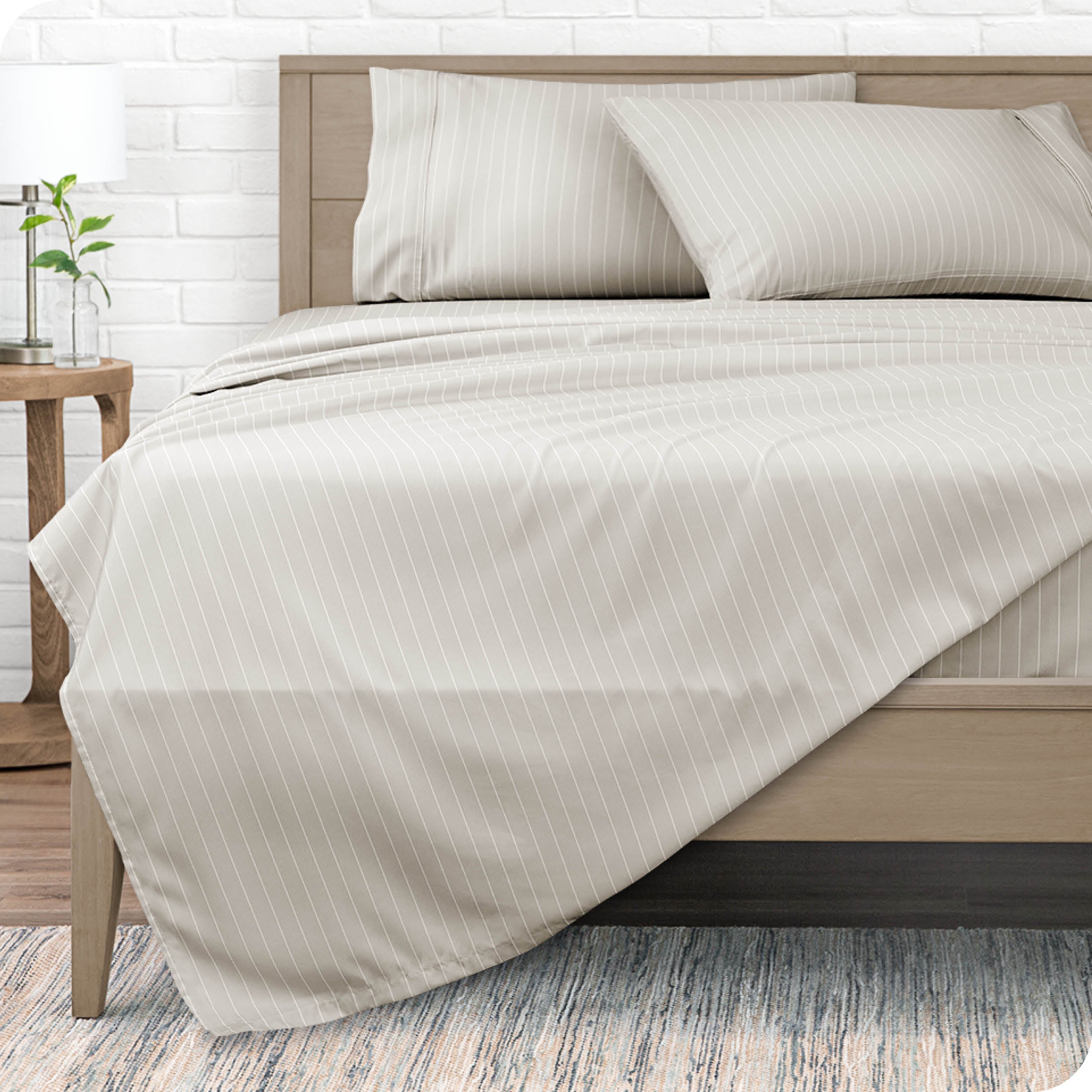 View from the end of a modern bed made with a microfiber sheet set with a modern print. 