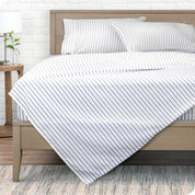 View from the end of a modern bed made with a microfiber sheet set with a modern print. 