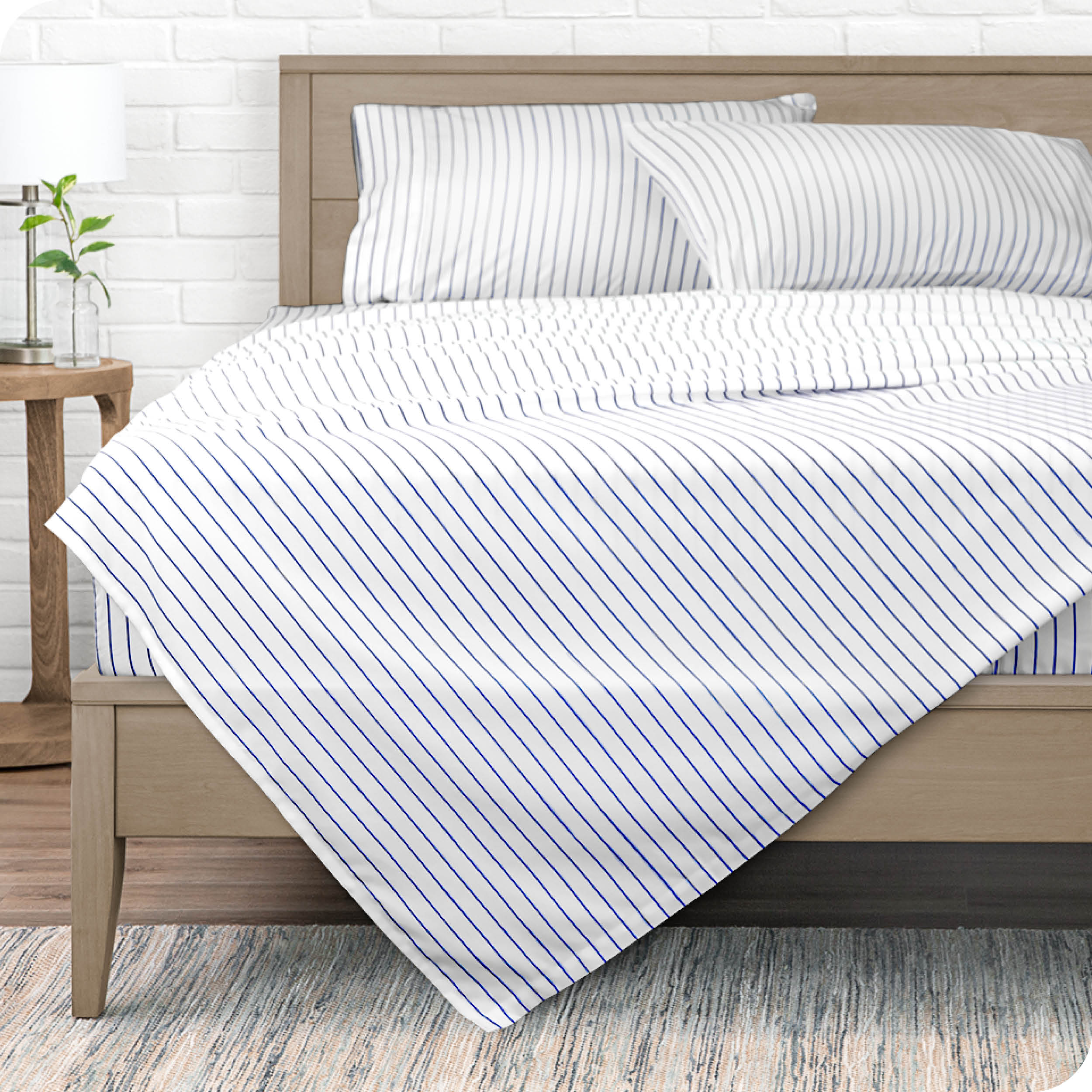View from the end of a modern bed made with a microfiber sheet set with a modern print. 