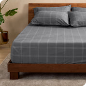 View for the end of a modern bed with a printed microfiber fitted sheet made with pillows. 