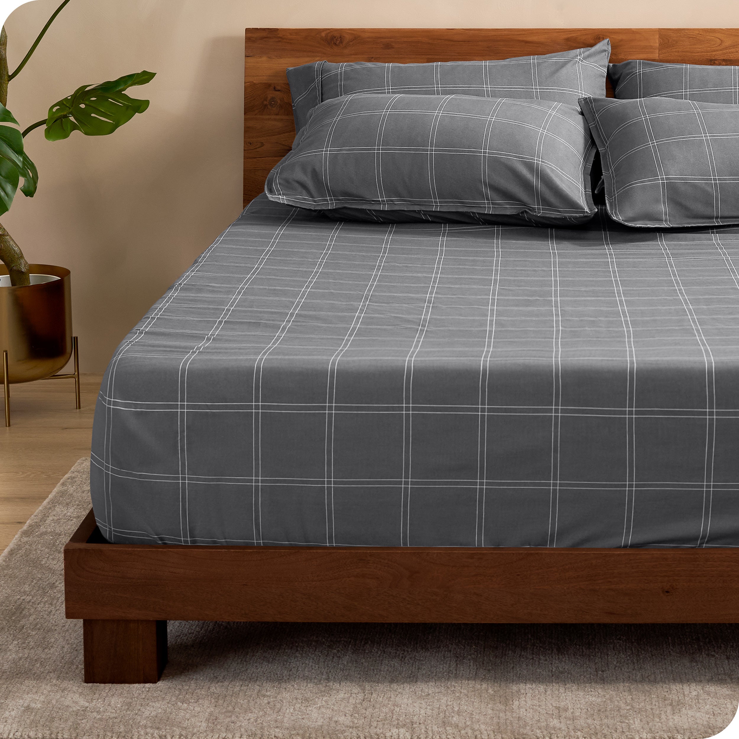 View for the end of a modern bed with a printed microfiber fitted sheet made with pillows. 