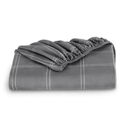 A neatly folded printed microfiber fitted sheet with elastic draped. 