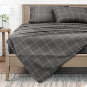 View from the end of a modern bed made with a microfiber sheet set with a modern print. 
