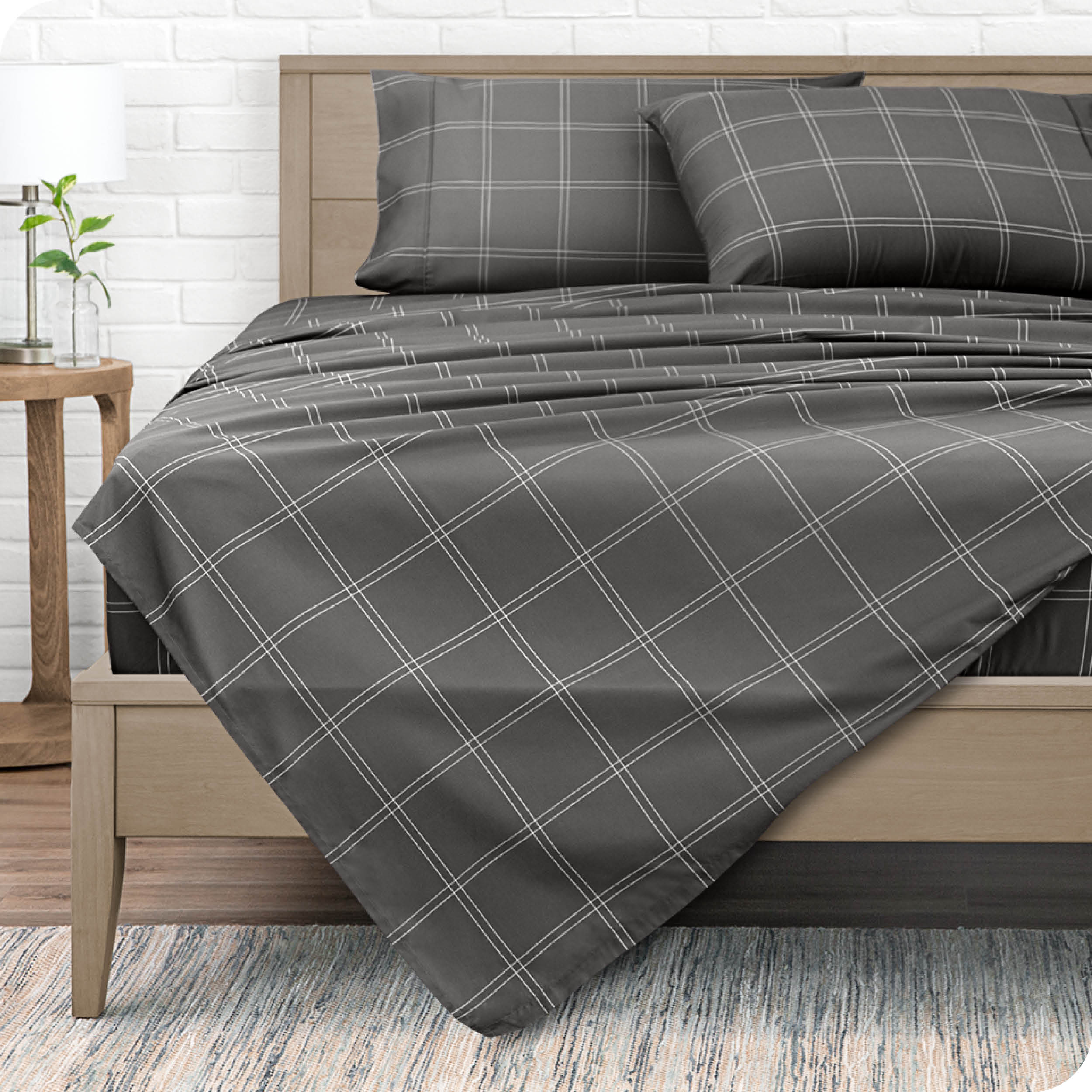 View from the end of a modern bed made with a microfiber sheet set with a modern print. 