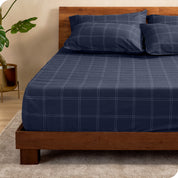 View for the end of a modern bed with a printed microfiber fitted sheet made with pillows. 