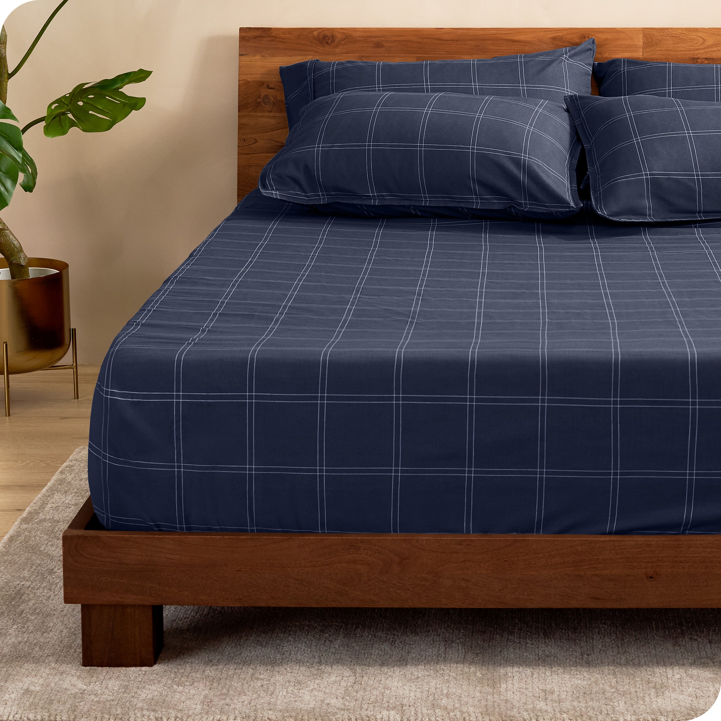 View for the end of a modern bed with a printed microfiber fitted sheet made with pillows. 