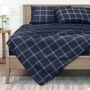 View from the end of a modern bed made with a microfiber sheet set with a modern print. 