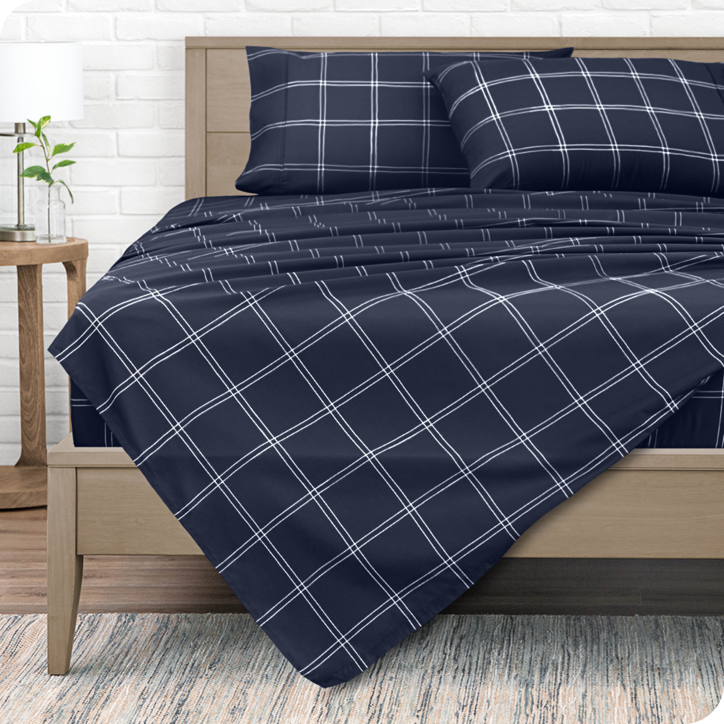 View from the end of a modern bed made with a microfiber sheet set with a modern print. 