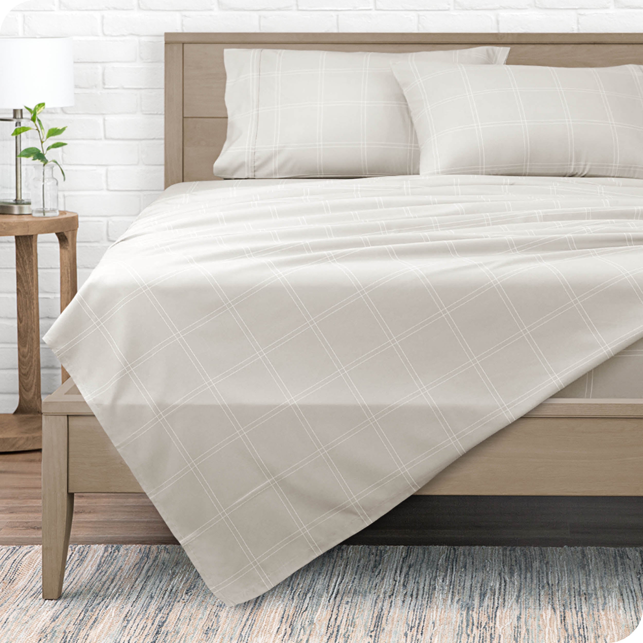 View from the end of a modern bed made with a microfiber sheet set with a modern print. 