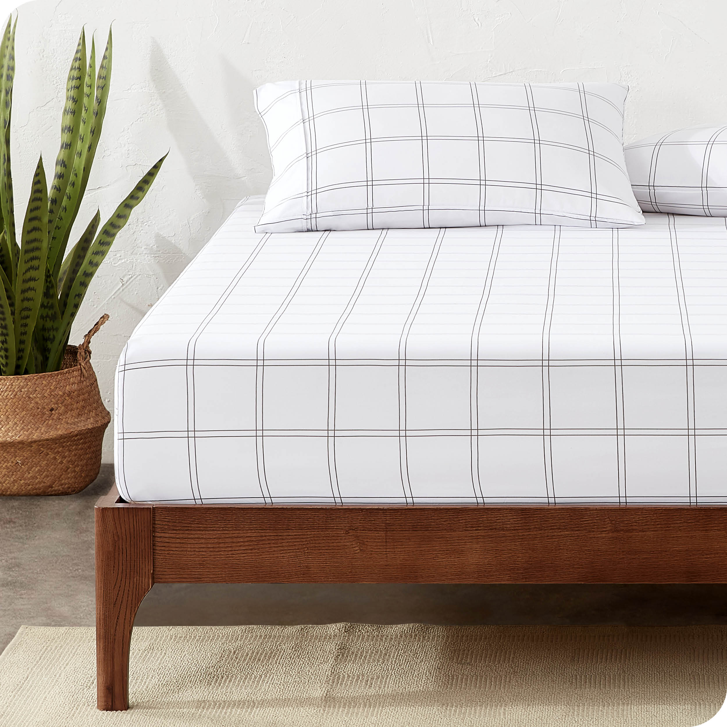View for the end of a modern bed with a printed microfiber fitted sheet made with pillows. 
