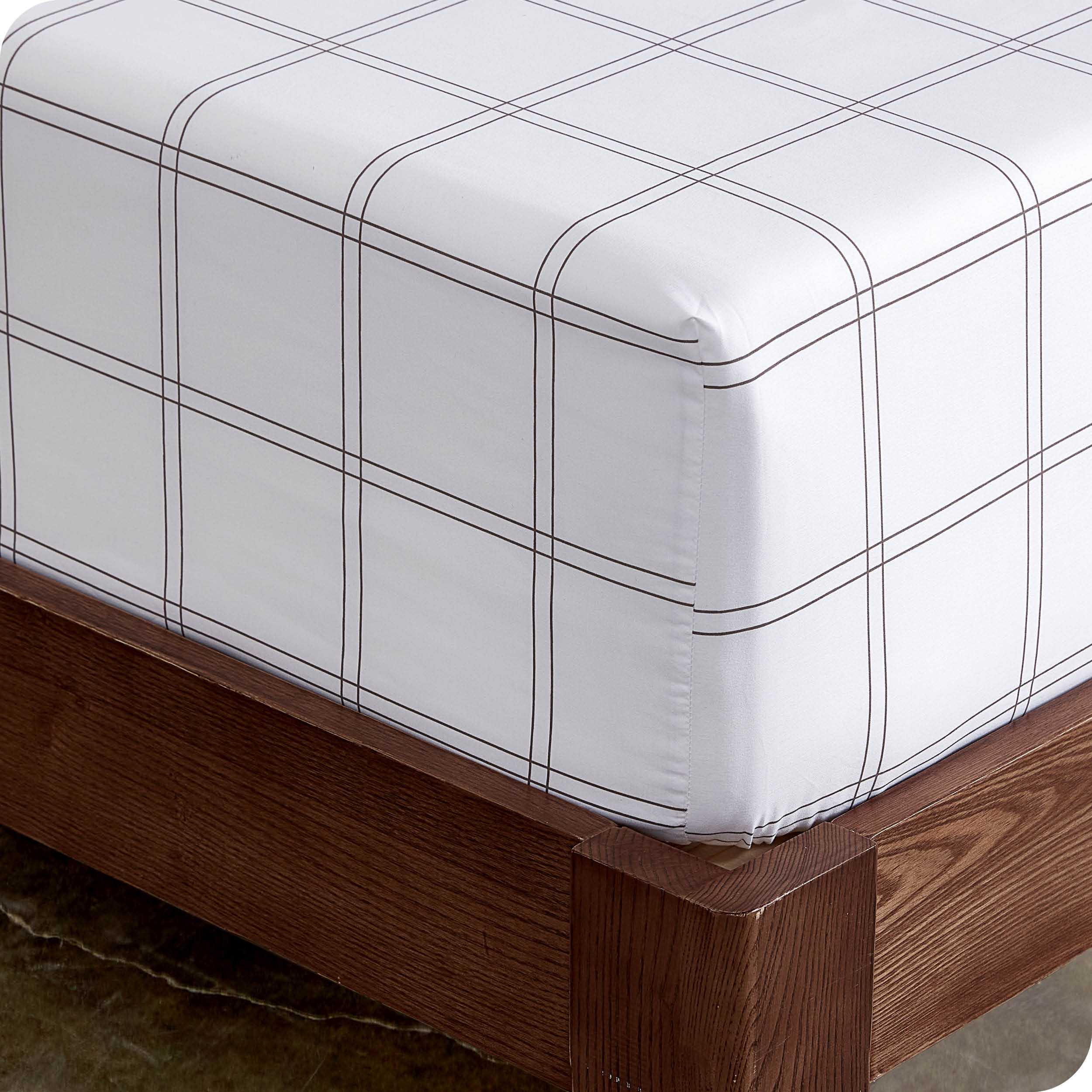 Close up view of the corner of a mattress with the microfiber fitted sheet to show how it fits. 