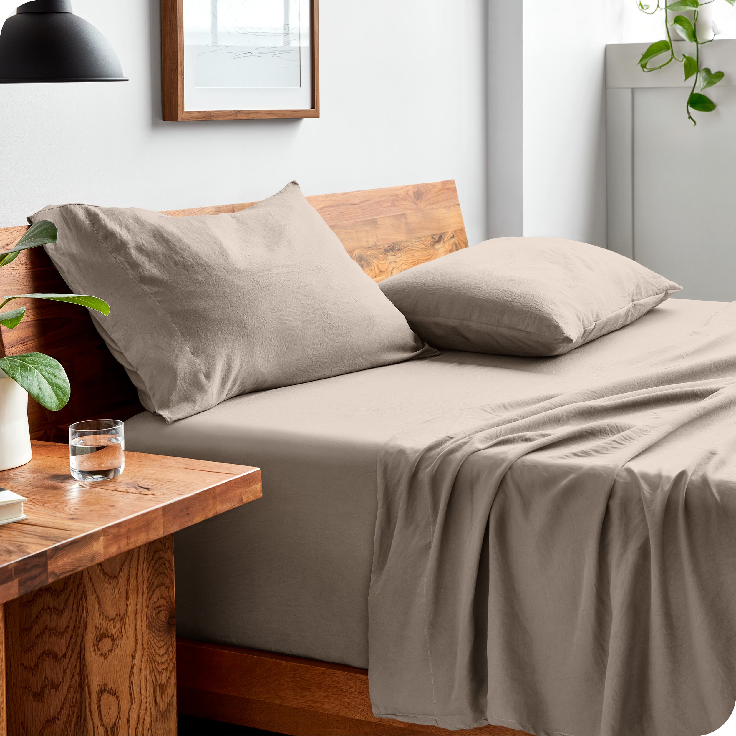 Side view of bed made with fitted sheet, pillowcases, and top sheet