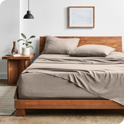 Modern bedroom with Sandwashed sheets draped over the end and side of mattress
