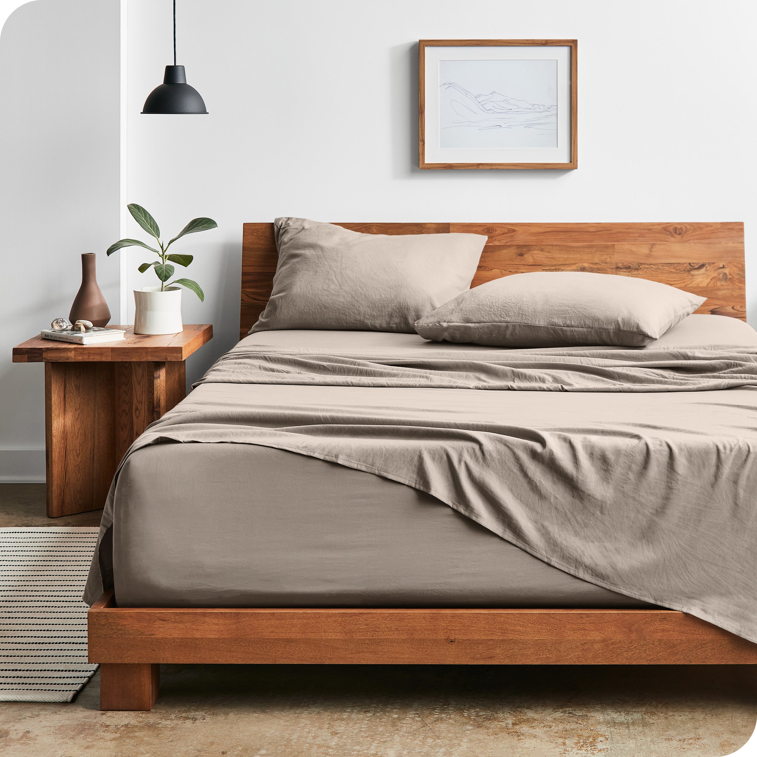 Modern bedroom with Sandwashed sheets draped over the end and side of mattress
