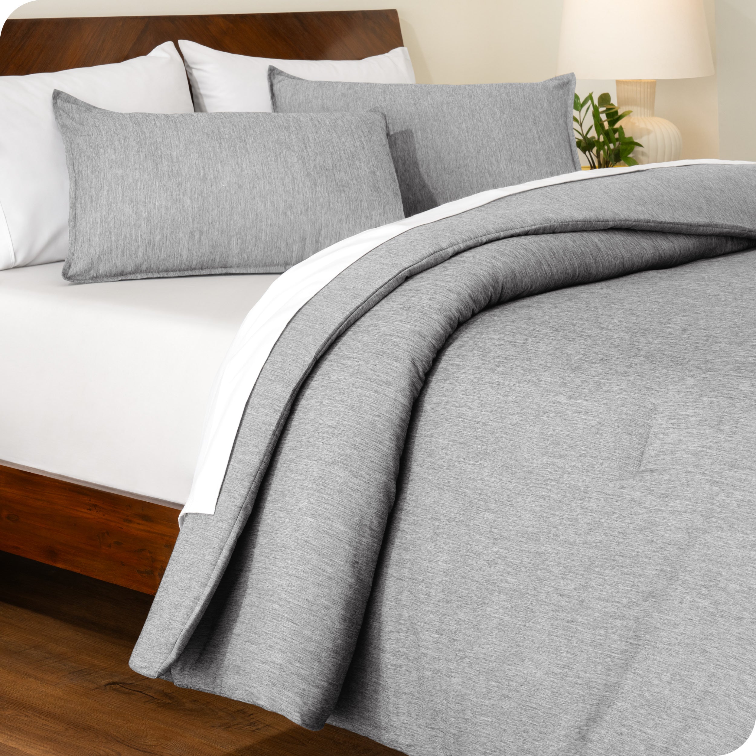 A side view of a modern bed with a comforter set and pillow shams on the bed

