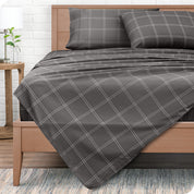View from end of a modern bed with microfiber flat sheet draped over. 