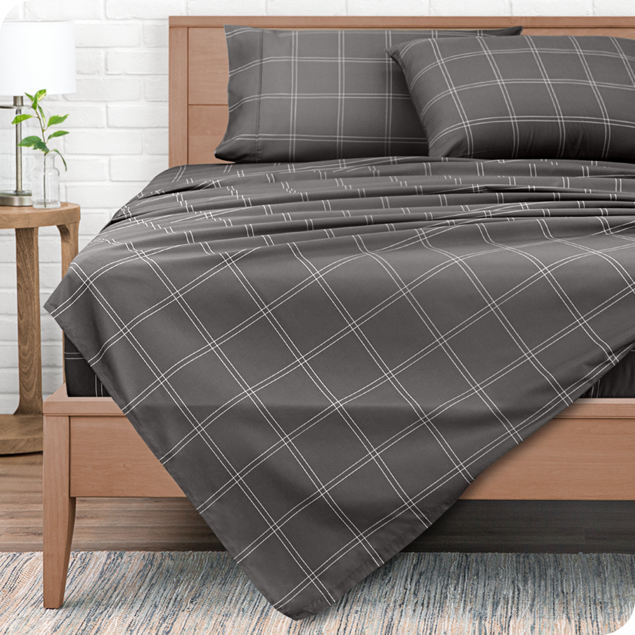 View from end of a modern bed with microfiber flat sheet draped over. 
